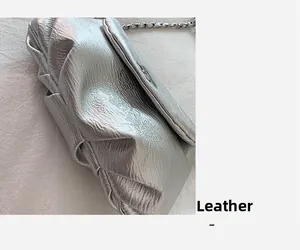 Nahaufnahme der metallisch silbernen Lederstruktur und Kette der Satteltasche