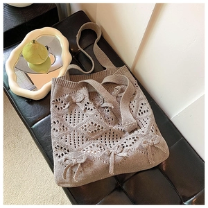 Gros plan sur un sac bandoulière beige au crochet avec tricot ajouré et nœuds doux