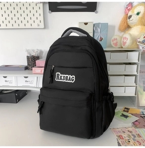Detail view of the black waterproof school backpack showing the front RKDBAG logo patch