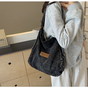 Dettaglio della borsa hobo in denim vintage con etichetta in pelle marrone e trama lavata
