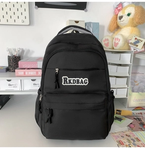 Detail of waterproof nylon backpack featuring black RKDBAG patch and gray handle