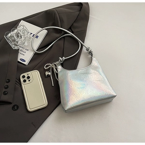 Detail of silver iridescent shoulder bag featuring pleated texture and pearl heart charm