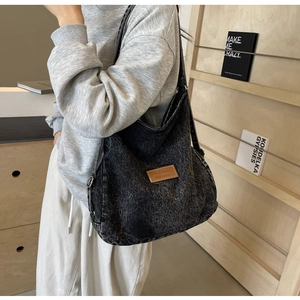 Dettaglio della borsa tote in denim lavato con patch in pelle e tracolla regolabile