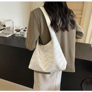 Detail of minimalist beige tote bag with grey wave stitching for daily commute