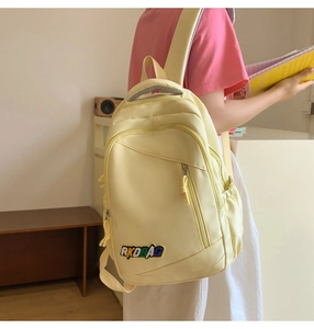 Detail of light yellow nylon backpack showing side pocket and high-capacity storage design
