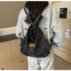Vista posteriore dello zaino in denim nero lavato con toppa in pelle in stile casual
