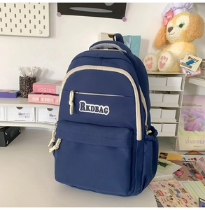 Detail of navy nylon backpack with RKDBAG embroidery and side drawstring pockets