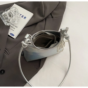 Detailed top view of silver metallic bucket bag with pearl chain and zipper compartment