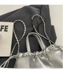 Détail du sac seau en cuir argenté métallisé avec bandoulière chaîne et cordon serrage