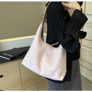 Close-up of the light pink tote bag featuring a unique wavy texture and pleated leather finish