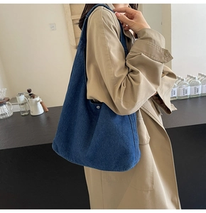 Détail du sac cabas en denim bleu foncé avec boucle argentée et texture style hobo