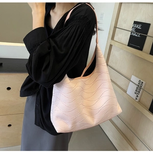 Detail view of the soft pink tote bag featuring unique wavy 3D textures on a hobo shoulder bag