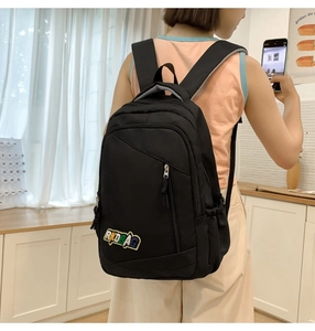 Detail of black backpack with RKDBAG embroidery showing side pocket and padded straps