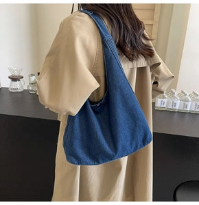 Vue détaillée du grand sac hobo en jean bleu foncé porté à l'épaule pour le loisir