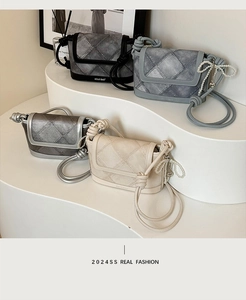 Close-up of four quilted denim crossbody bags with pearl bow charms and knotted straps