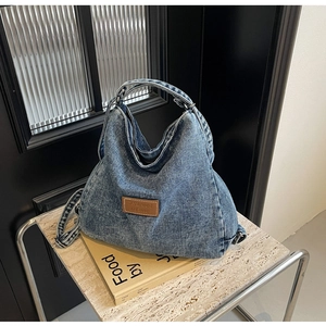 Dettaglio della borsa tote in denim lavato vintage con patch logo in pelle