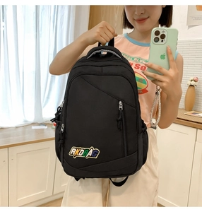 Close-up of black nylon backpack featuring colorful RKDBAG embroidered patch and zippers