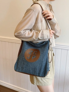 Retro denim tote bag with brown leather straps and adjustable shoulder handle