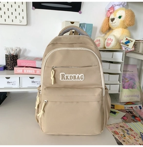Detail view of khaki waterproof backpack with RKDBAG embroidery and zipper pockets