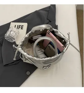Vue intérieure d'un sac seau plissé argenté montrant sa grande capacité pour tablettes