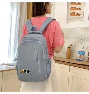 Detail of light blue nylon backpack with RKDBAG embroidery and front zipper pocket
