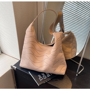 Detail of beige tote bag featuring wave stitching texture on soft material
