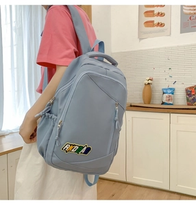 Light blue nylon backpack with multiple pockets and AKOBAO embroidery for students