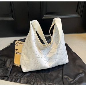 Detail showing the white wavy textured PU leather surface of a large capacity tote bag