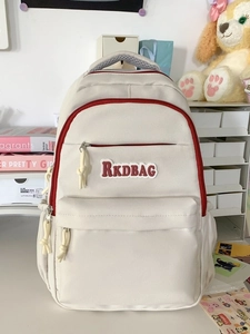 Minimalist beige backpack with red contrast zippers and large capacity for travel use