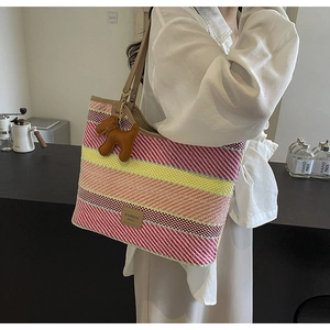 Dettaglio della borsa tote intrecciata colorata con etichetta e ciondolo a cane
