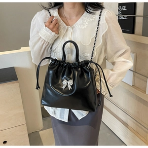 Détail du sac seau noir avec nœud en strass et bandoulière en chaîne argentée