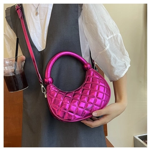 Detail of fuchsia patent leather crossbody bag with quilted pattern and silver round handle