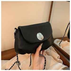Nahaufnahme der schwarzen Satteltasche mit Knitteroptik, Schnalle und Kettenriemen