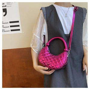 Macro shot of hot pink metallic quilted crescent handbag with round handle and chain