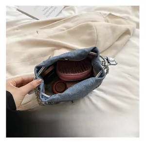 Detail view of denim bucket bag interior showing capacity for wallet and makeup