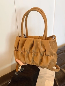 Camel pleated dumpling bag with dual handles and crossbody strap for a stylish look