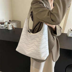 Women's casual tote bag with wavy texture design shown in a minimalist lifestyle setting