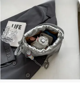 Sac argenté matelassé avec chaîne montrant un grand espace intérieur de rangement