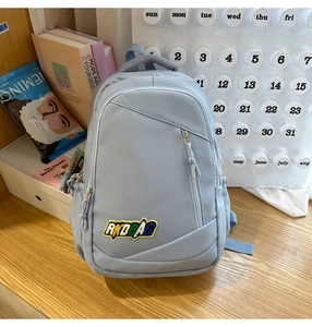 Close-up of light blue waterproof nylon backpack featuring colorful RKDBAG letter embroidery