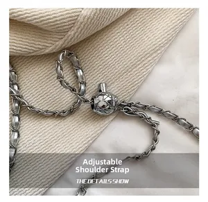 Detail of adjustable silver chain strap with quilted metal ball and gray leather weave