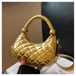 Detail of metallic gold quilted dumpling bag with leather texture and chain strap