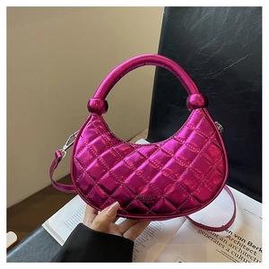 Detailed macro view of quilted texture on metallic pink crescent handbag with handle