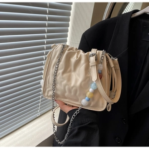 Détail du sac nuage plissé crème avec surpiqûres étoiles et chaîne en perles colorées