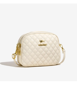 Détail d'un sac bandoulière crème matelassé avec logo métallique kangourou doré