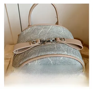 Gros plan sur les ferrures argentées brillantes et le tissu texturé du sac à dos