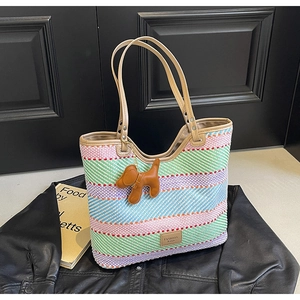 Dettaglio borsa tote in paglia a strisce colorate con charm a forma di cane