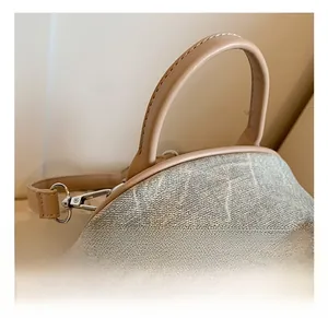Vue détaillée du sac à dos en jacquard kaki avec poignée en cuir et crochet en métal