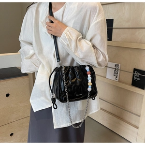 Détail du sac seau plissé noir avec chaîne argentée et perles colorées