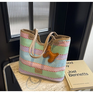 Dettaglio della borsa tote in paglia colorata con ciondolo a forma di cane