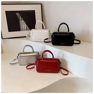 Detail of four colorful crossbody square bags in white, black, silver, and red leather